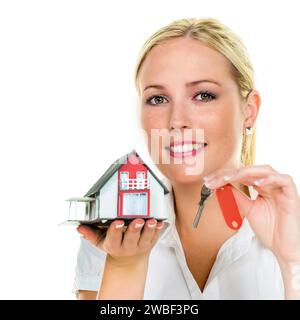 Eine Frau beschützt Ihr Haus und Ihr Zuhause. Gute Versicherung und ernsthafte Finanzierung beruhigen, blond, 30 Jahre, Modellhaus, Hausschlüssel Stockfoto