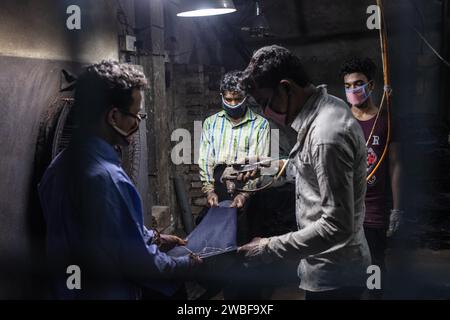 Arbeiter, die in einer Textilfabrik in Dhaka, Bangladesch, Jeans ausmalen Stockfoto