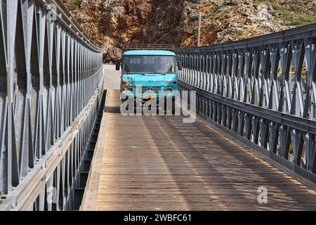 Ein blauer Lastwagen fährt über eine Brücke in bergiger Umgebung, Aradena Gorge, Aradena, Sfakia, Kreta, Griechenland Stockfoto