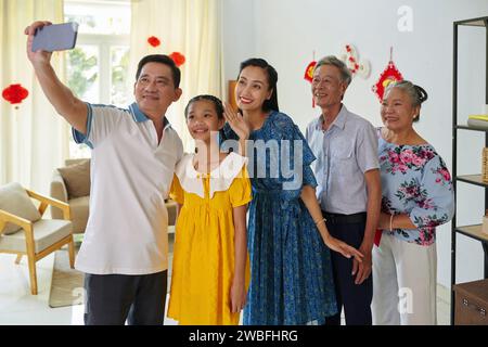 Glückliche vietnamesische Familie posiert für Gruppen-Selfie auf der Tet-Party Stockfoto