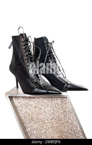 Schwarze Vintage-High-Heels mit Bleistiftabsätzen zum Schnüren mit Loafern mit Nieten als Ausstellung und Kunstobjekt Stockfoto