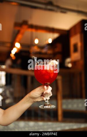 Beliebte Bar Sommer Eis alkoholische Cocktails. Aperol Spritz und Erdbeerbasilikum Margarita in Gläsern in Frauenhand im Stadtcafé Stockfoto