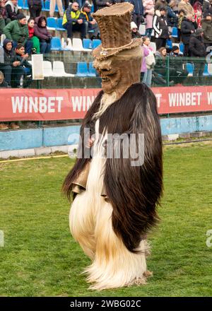 Mummer aus Zentralbulgarien trägt seltsame Maske und Kostüm beim jährlichen Simitlia-Festival in Simitli, Blagoevgrad County, Bulgarien, Europa, Balkan Stockfoto