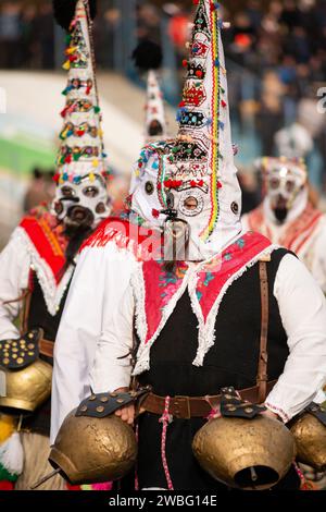 Typische Kukeri Startsi Tänzer mit konisch komplizierten Masken und großen Glocken beim Simitlia Festival in Simitli, Bulgarien, Osteuropa, Balkan Stockfoto