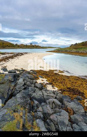 Am Ufer am Meer, Sandstrand mit Grillplatz auf Sommarøy am Nordatlantik. Bootshaus auf den Inseln von Kvaløya. Urlaubsreisen Stockfoto