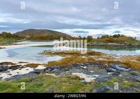 Am Ufer am Meer, Sandstrand mit Grillplatz auf Sommarøy am Nordatlantik. Bootshaus auf den Inseln von Kvaløya. Urlaubsreisen Stockfoto