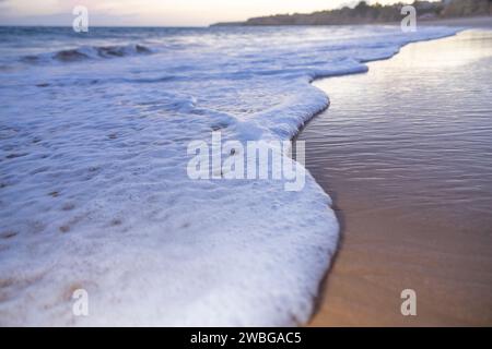 Meerwasser sanfte Wellen krachen am Sandstrand am Abend. Hintergrundkonzept für Sommerurlaub. Stockfoto