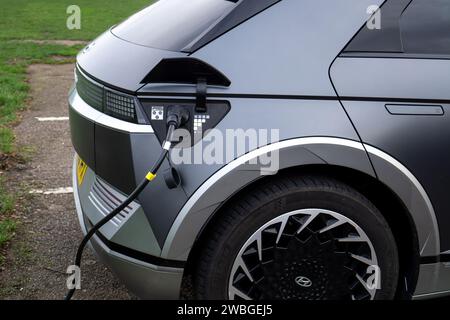 Nahaufnahme des Elektroautos Hyundai Ioniq 5 mit EV-Ladestation Stockfoto