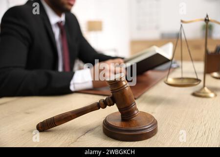 Der Anwalt liest Buch am Tisch im Büro, konzentriert sich auf den Hammer Stockfoto