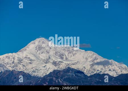 Ein majestätischer, schneebedeckter Berg erhebt sich hoch vor einem klaren blauen Himmel und zeigt die Schönheit und Pracht der Natur. Stockfoto