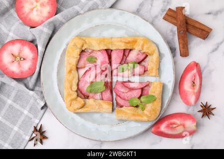 Köstliche Apfelgalette mit Minze und Zutaten auf weißem Marmortisch, flach gelegen Stockfoto