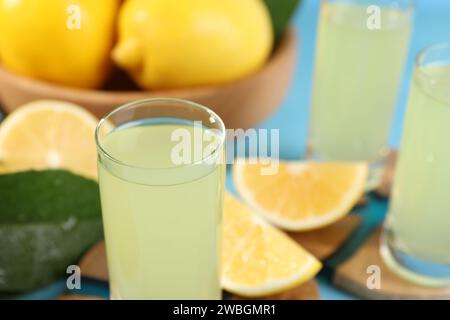 Leckerer Limoncello-Likör und Zitronen auf dem Tisch, Nahaufnahme. Leerzeichen für Text Stockfoto