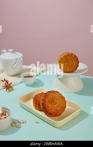 Kürbiskerne in einer Schüssel mit leckeren Mondkuchen auf Keramikgeschirr und einem Teeset. Das Herbstfest wird nach und nach zu einem Familienfest Stockfoto