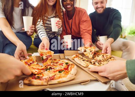 Junge Leute Freunde treffen sich in der Pizzeria oder zu Hause essen Pizzascheiben genießen Party. Stockfoto