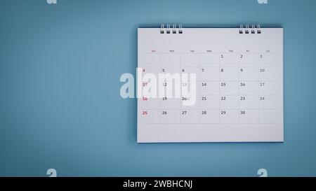 Weißer Kalender, der auf blauem Hintergrund liegt. Stockfoto