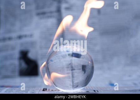 Glaskugel in Flammen. Planet Erde Brennt. Klimaerwärmung und Klimaschutzkonzept. Stockfoto