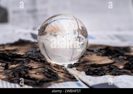 Glaskugel in Flammen. Planet Erde Brennt. Klimaerwärmung und Klimaschutzkonzept. Stockfoto