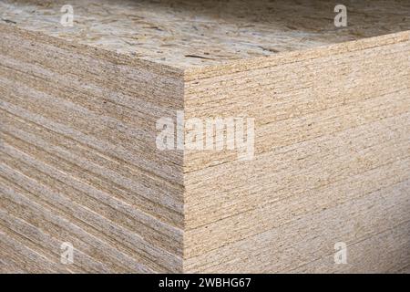 Der Stapel der OSB-Platten wird in einem Baumarkt auf einer Palette gestapelt. Sperrholz mit Fragmenten von komprimiertem Sägemehl, für den Bau vorbereitet. Selektiv Stockfoto
