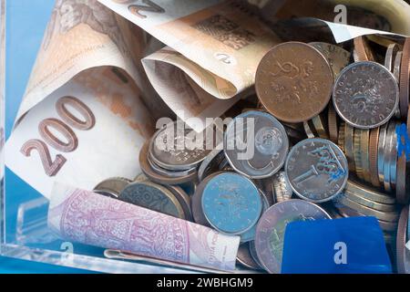 Wohltätigkeits- und Geldgeld CZK tschechische Kronen-Banknoten in einer transparenten Spendenbox für Geldspenden. Eine finanzielle Unterstützung, sammelt Geld. Der Akt des Gebens Stockfoto