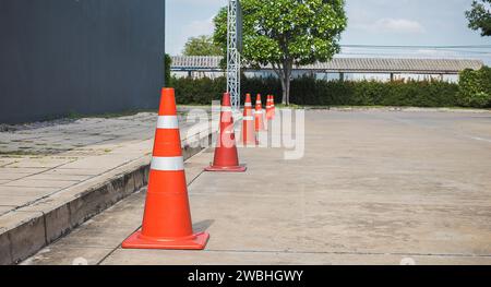 Orangefarbene Verkehrskegel auf Betonstraße Stockfoto