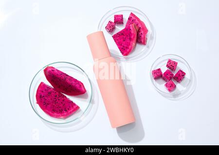 Eine Flasche in Tintenfarbe wird mit Petrischalen aus rotem Drachenfrucht ausgestellt. Drachenfrucht (Hylocereus) enthält Vitamin C, das ein starkes Vitamin ist Stockfoto