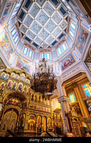 Blick auf den goldenen Altar mit einer hohen, weißen Kuppeldecke, die religiöse Gemälde zeigt. An der Himmelfahrt, Zenkov Holzkathedrale in Panfi Stockfoto
