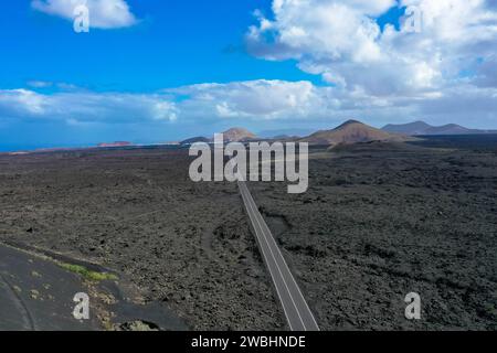 Panoramaansicht der leeren Asphaltstraße LZ-67 in der vulkanischen Landschaft des Timanfaya Nationalparks, Lanzarote, Kanarischen Inseln, Spanien, Europa Stockfoto