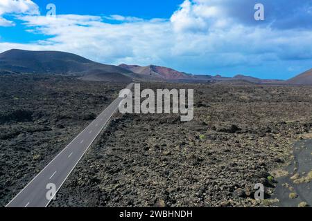 Panoramaansicht der leeren Asphaltstraße LZ-67 in der vulkanischen Landschaft des Timanfaya Nationalparks, Lanzarote, Kanarischen Inseln, Spanien, Europa Stockfoto