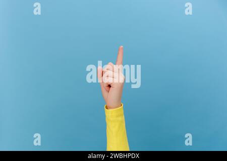 Nahaufnahme einer weiblichen Hand, die nach oben zeigt, wie ein leerer Bereich auf einer kommerziellen Hintergrundschleife für den blauen leeren Raum gezeigt wird. Empfehlungszeichen. Mit Ort für Text oder Stockfoto