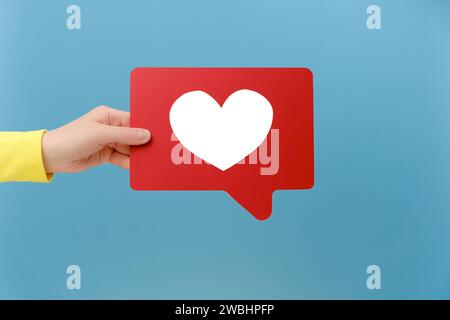 Nahaufnahme einer Frau Hand, die soziale Medien wie Stick, Emoji-Benachrichtigungsschaltfläche hält, um Blog oder Post zu verfolgen und zu abonnieren, populäres Forum, posiert isoliert Stockfoto