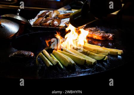 Würstchen und gegrilltes Gemüse am Lagerfeuer zubereiten. Erholung und Sommercamping auf dem Land. Nacht. Stockfoto