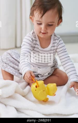 Baby, Spiel und Spielzeug im Wohnzimmerboden, Ente und sensorisches Wachstum im Familienhaus. Neugierig, Mädchen und Spiel für kindliche Entwicklung, Spiele und Kindheit Stockfoto