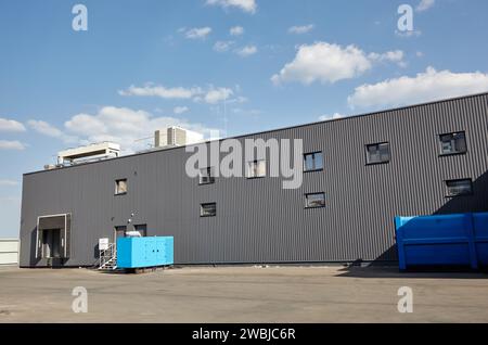 Laderampen eines Lagers. Wellblechlager Industriegebäude vor blauem, klarem Himmel Stockfoto