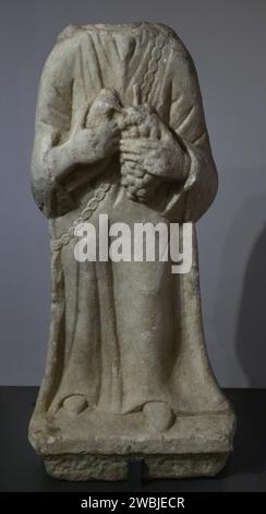 Weibliche Figur mit Opfergaben (Vogel und Trauben). 1.-2. Jahrhundert n. Chr. Überreste einer Statue, die im römischen Tempel des Endovelicus in Sao Miguel da Mota gefunden wurde. Terena, Alandroal, Evora. Portugal. Nationalmuseum Für Archäologie. Lissabon, Portugal. Stockfoto