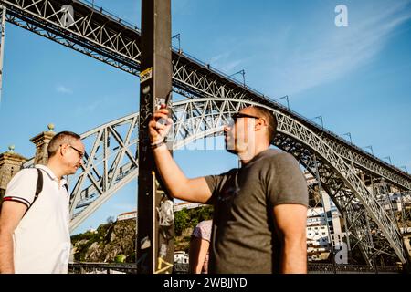 17. April 2023 - Porto, Portugal: Berühmte eiserne Dom Luis-Brücke mit Selfie im Vordergrund Stockfoto