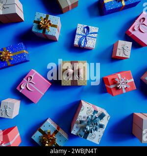 Eine sorgfältig angeordnete Auswahl an lebendigen, gemusterten Geschenkboxen mit festlichen Bändern liegt vor einem auffälligen blauen Hintergrund, perfekt für einen Stockfoto