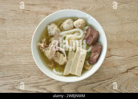 Vietnamesische Reisnudeln oder Pho mit Wurstscheiben und Schweinefleisch sowie Blut in Suppe auf einer Schüssel Stockfoto