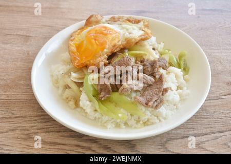 Scharfe, gebratene Rindfleischscheibe mit langer süßer Chili und Zwiebeln auf Reis, das Ei im Teller garniert Stockfoto