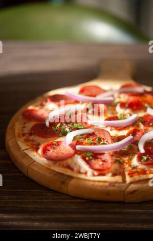 Eine appetitliche Pizza mit roten Zwiebeln und Peperoni Stockfoto