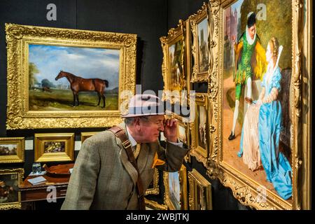 London, Großbritannien. Januar 2024. Ein Sammler untersucht Ölgemälde in Cambridge Fine Arts - der Mayfair Antiques & Fine Art Fair, London Marriott Hotel Grosvenor Square. Guy Bell/Alamy Live News Stockfoto