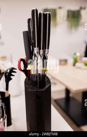 Messer in schwarzem Block auf Küchentisch. Stockfoto