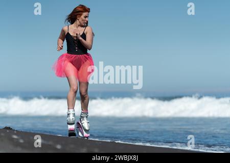 KAMTSCHATKA, RUSSLAND - 15. JUNI 2022: Fitness-Frau im Sport Kangoo springt Stiefel, schwarzer einteiliger Badeanzug und kurzer rosafarbener Rock Laufen und Springen auf s Stockfoto