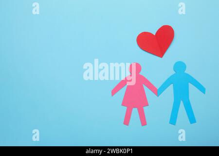 Papierfamilie und Herz auf blauem Hintergrund. Liebes- und Familienkonzept. Draufsicht Stockfoto