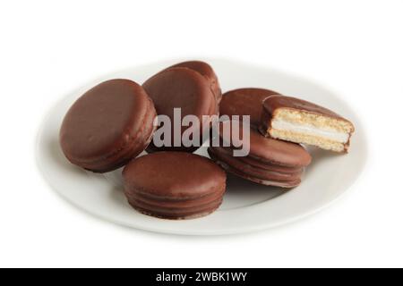 Schokoladenkuchen mit Schokolade überzogene Snacks in Teller isoliert auf weißem Hintergrund. Draufsicht Stockfoto