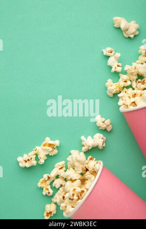 Popcorn in rosa Bechern. Drei Tassen Popcorn auf mintfarbenem Hintergrund. Süßes Popcorn. Draufsicht Stockfoto