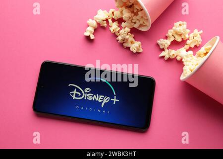 Nikolaev, Ukraine - 20. November 2021. Filme und Serien nach Abonnement, Konzept. Smartphone mit Disney Plus-Logo auf rosa Hintergrund. Draufsicht Stockfoto