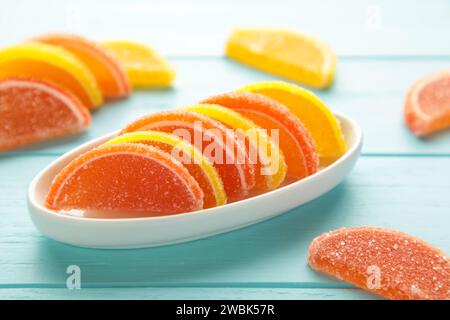 Dessertmarmelade in Form von Zitronen- und Orangenscheiben in Teller auf blauem Hintergrund. Draufsicht Stockfoto