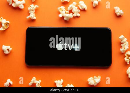 Nikolaev, Ukraine - 20. November 2021. Smartphone mit Apple TV-Logo und Popcorn auf orangem Hintergrund. Draufsicht Stockfoto