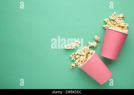 Popcorn in rosa Bechern. Drei Tassen Popcorn auf mintfarbenem Hintergrund. Süßes Popcorn. Draufsicht Stockfoto