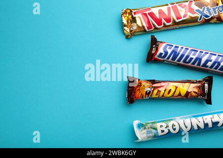 Snickers, Mars, Bounty und Twix Schokoladenriegel auf blauem Hintergrund. Draufsicht. Nikolaev, Ukraine - 19. Dezember 2021 Stockfoto